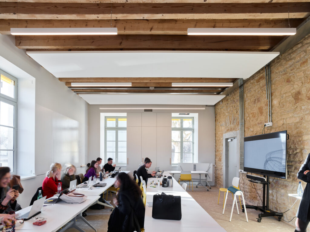 Classe avec deux rangées de tables de profil, et des élèves qui y travaillent