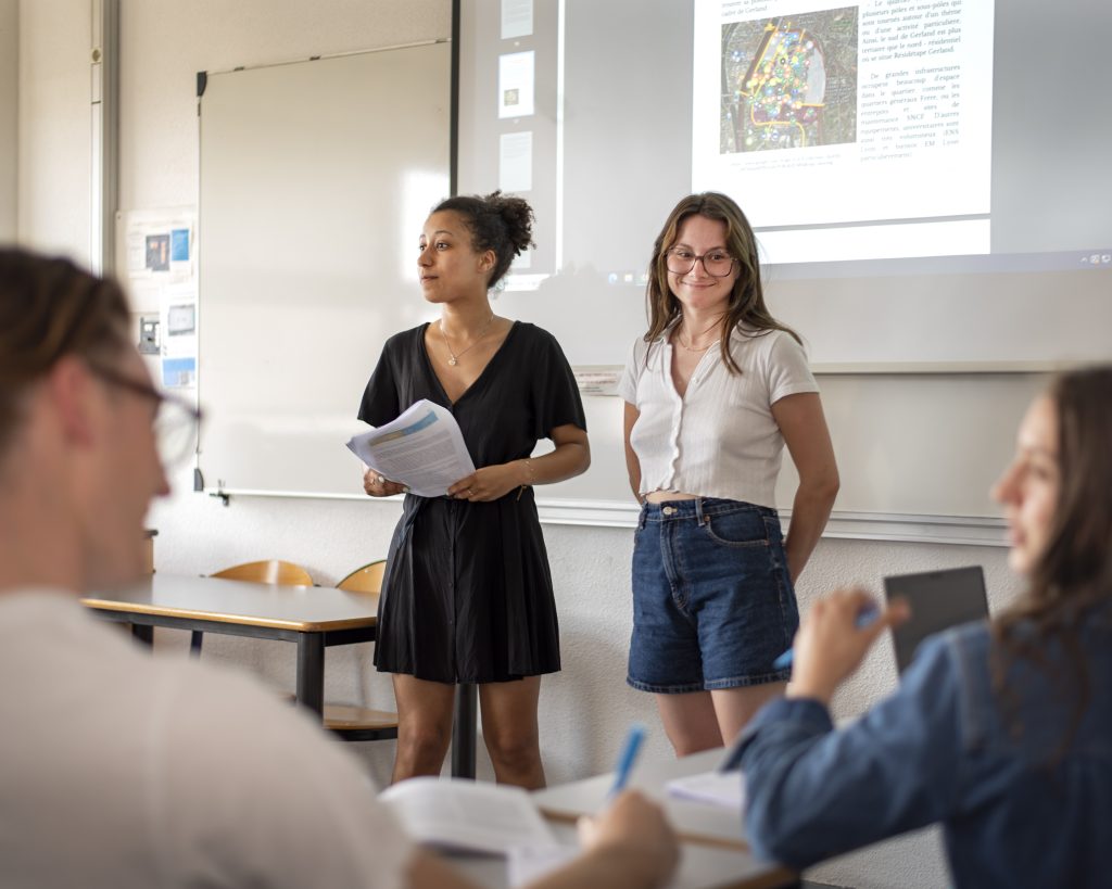 2 élèves qui font une présentation devant une classe