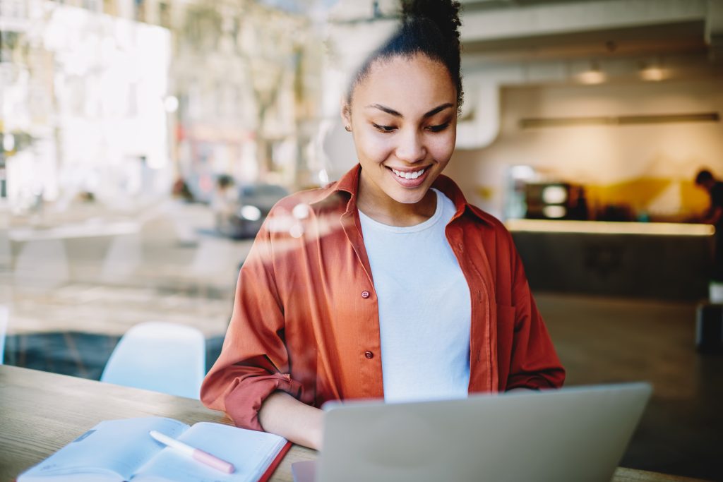 Femme qui sourit devant son ordinateur